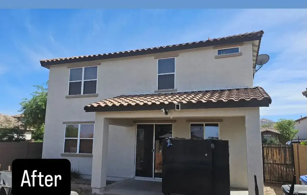 After: the same home repainted in clean cream with fresh brown trim