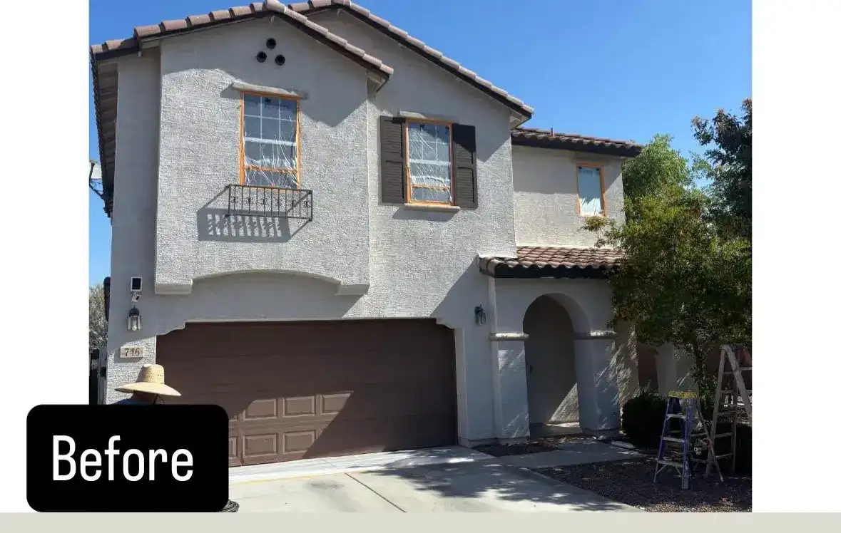 Before: two-story home with dated grey stucco, windows masked for painting