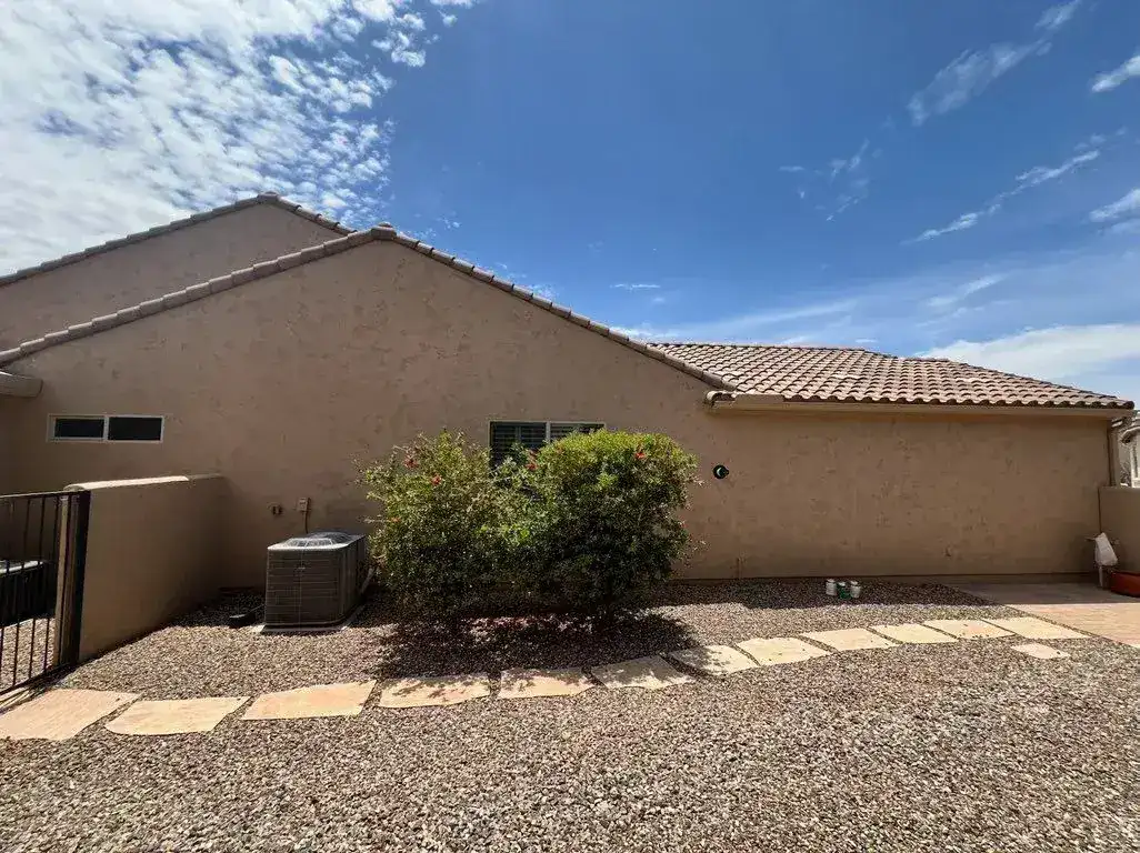 Finished side elevation of a stucco home with an even new coat of paint
