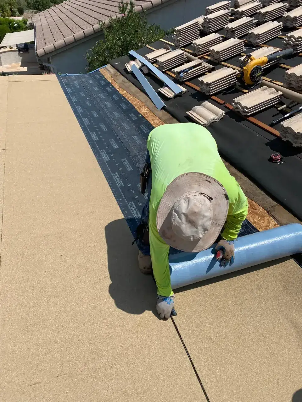 Crew rolling out modified bitumen cap sheet on a flat roof